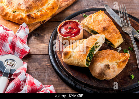 Italienische Küche, Pizza Calzone mit Spinat und Käse, Holz- Hintergrund, kopieren Raum Stockfoto