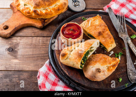 Italienische Küche, Pizza Calzone mit Spinat und Käse, Holz- Hintergrund, kopieren Raum Stockfoto