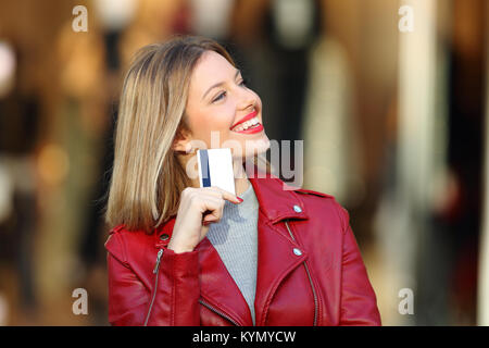 Portrait Of Happy shopper Fragen zu kaufen Was halten Sie eine Kreditkarte mit einer Verkaufsplattform im Hintergrund Stockfoto