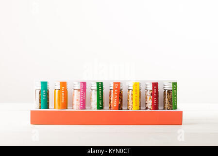 Gewürze in kleinen Flaschen, wie Basilikum, Kurkuma, Salz, Chili Flocken, Kreuzkümmel auf hellen Hintergrund Stockfoto