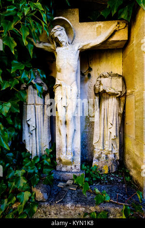 Mit Efeu bewachsenen Friedhof Denkmal von Jesus am Kreuz Stockfoto