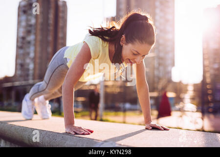 Bild der Frau tun, Push-ups im städtischen Bereich Stockfoto