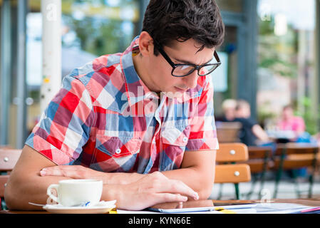 Man trinkt Kaffee in Street Cafe Lesung am tablet device Stockfoto