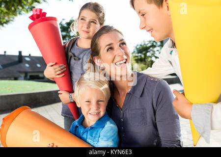 Frau und Kinder an der Einschreibung Tag mit Schule Kegel Stockfoto