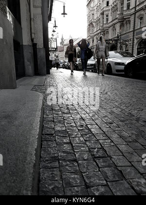 Prag, tschechische Republik - 30. AUGUST 2017; Frauen zu Fuß in der Altstadt Straße in Prag am frühen Abend Licht glitzert auf kopfsteinpflaster als Licht erlischt. Stockfoto