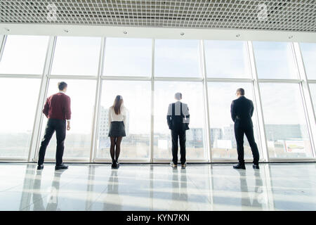 Rückansicht Silhouetten von fouw Geschäftspartner nachdenklich durch ein Büro. Mannschaft der Geschäftsleute, die in der Furcht oder Risiko beobachten Stadtbild Stockfoto