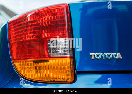 Nahaufnahme eines Heckleuchte eines blauen Toyota Auto mit der Marke / Logo in metallischen Buchstaben Stockfoto