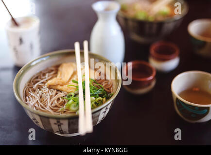 Schüssel mit Ramen mit Soba-nudeln und Tofu auf einem Tisch in einem Japanischen Restaurant, Kyoto, Japan. Stockfoto