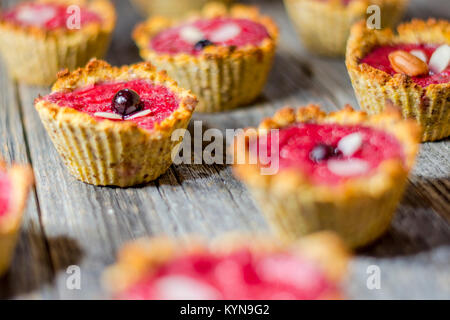 Himbeer Muffins auf einem alten Holztisch Stockfoto
