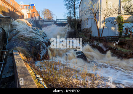 Ronneby, Schweden - 7. Januar 2018: Dokumentarfilm von Alltag und Umwelt. Die Stadt Wasserfall an einem kalten Tag mit Eis auf den Felsen. Dam Tore sind Stockfoto