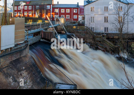 Schleusen an der Stadt Wasserfall in Ronneby, Schweden öffnen. Überschwemmen stromaufwärts macht das Wasser überlaufen. Häuser im Hintergrund. Stockfoto