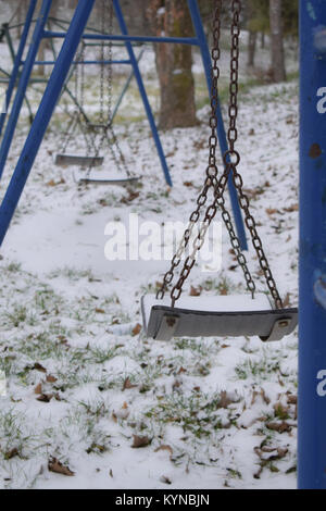 Lonely blue schaukeln auf dem Spielplatz Park auf Schnee, Winter Stockfoto