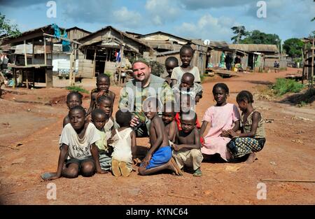 Zentral-afrikanische Republik, AFRIKA - 2008 Oktober 29: Eine europäische Tourist wirft mit der lokalen Kinder auf der Landstraße, in einem kleinen Dorf im Zentrum Stockfoto