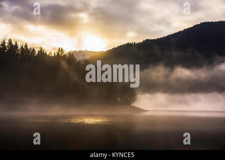 Eine schöne Misty Sonnenuntergang auf der Kruth-Wildenstein See im Winter, Vogesen, Frankreich. Stockfoto