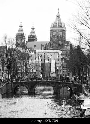 Die Oudezijds Voorburgwal eine Straße und Kanal in das rotlichtmilieu im Zentrum von Amsterdam. Im Hintergrund die Basilika von St. Nikolaus. Schwarz a Stockfoto