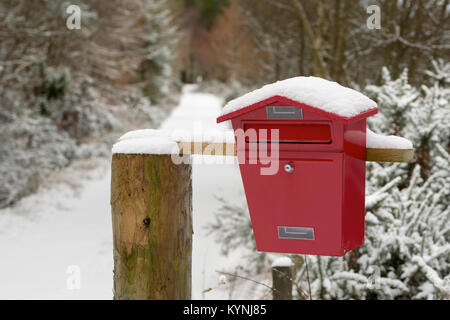 Eine rote Metall Briefkasten, dargestellt im Schnee, die Maschine am Ende einer Spur irgendwo in Schottland. Stockfoto