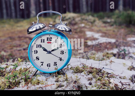Vintage blau Wecker auf Winter Wald Hintergrund Stockfoto