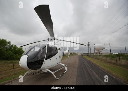 In Eagle Pass, Texas, überwacht ein US-amerikanischer Zoll- und Grenzschutzhubschrauber EC-120 eine TARS-Anlage (Tethered Aerostat Radar System), die für Grenzsicherheit und Betäubungsmittelverbot genutzt wird. Stockfoto
