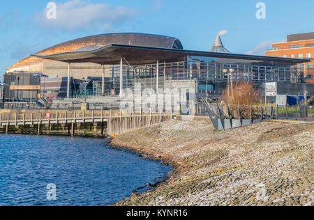 Cardiff Bay, das die Diskussionskammer des Senedd Building und das Kupferdach des Millennium Center an einem sonnigen Tag zeigt Stockfoto