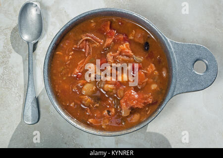 Geräuchertes Fleisch von Truthühnern und Bohnensuppe in Metall Soup Bowl. Es ist eine klassische Suppe Rezept mit geräuchertem Türkei, Tomaten, Sellerie und Zwiebeln. Stockfoto