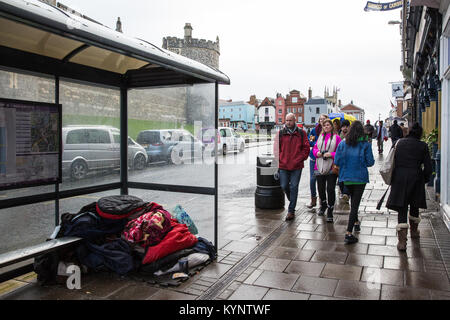 Windsor, Großbritannien. 15 Jan, 2018. Eine obdachlose Person schläft unter einer Bushaltestelle gegenüber von Schloss Windsor bei feuchter Witterung. Credit: Mark Kerrison/Alamy leben Nachrichten Stockfoto