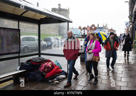 Windsor, Großbritannien. 15 Jan, 2018. Eine obdachlose Person schläft unter einer Bushaltestelle gegenüber von Schloss Windsor bei feuchter Witterung. Credit: Mark Kerrison/Alamy leben Nachrichten Stockfoto