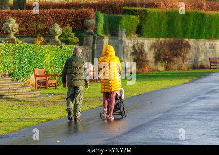 Glasgow, Schottland, Großbritannien. 15 Jan, 2018. UK Wetter: An einem kalten, sonnigen Nachmittag im pollok Country Park, Eltern drücken einen Kinderwagen durch den Park während trotzen dem Hagel und Graupel. Credit: Skully/Alamy leben Nachrichten Stockfoto