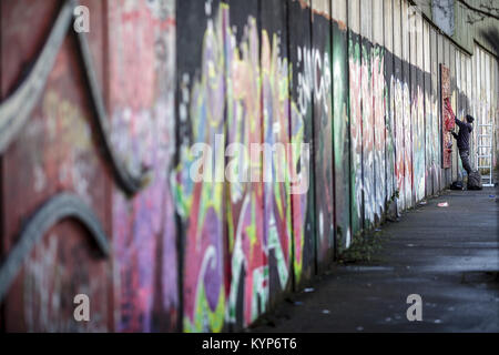 Belfast, Nordirland. 27 Feb, 2017. Ein Graffiti artist Sprays auf einen Frieden Wand in einem pro-britischen Teil von Belfast, Nordirland, 27. Februar 2017. Mächtige Mauern und Zäune aus Metall Schlange durch Belfast, einige über zwölf Meter hoch und gekrönt von Stacheldraht. Sie getrennte Wohngebiete von einander, in gerader Linie oder in einem Zick-Zack-Kurs. Die Katholiken leben auf der einen Seite, die Protestanten auf der anderen. Credit: Mariusz Smiejek/dpa | Verwendung weltweit/dpa/Alamy leben Nachrichten Stockfoto