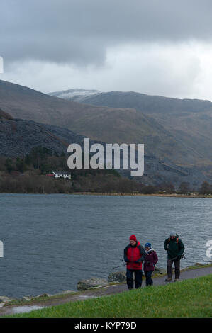 Llanberis, Gwynedd, Wales, UK. 16 Jan, 2018. Menschen gehen von Llyn Padarn in Llanberis in Gwynedd, Wales, UK. An einem kalten und windigen Morgen nach fiel Schnee auf den Gipfeln in Snowdonia letzte Nacht. Credit: Graham M. Lawrence/Alamy leben Nachrichten Stockfoto