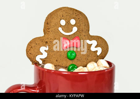 Lächelnd Gingerbread Man in heißen Kakao trinken mit Marshmallows in rot Tasse Stockfoto