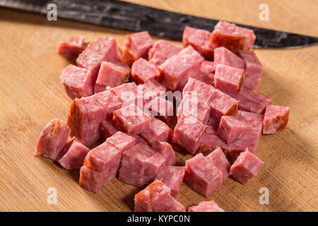 Stücke geschnitten italienische Salami mit Messer auf einem Schneidebrett Stockfoto