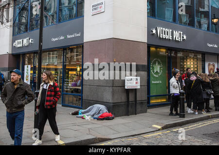 London, Großbritannien. 13. Januar, 2018. Eine obdachlose Person schläft außerhalb einer Niederlassung der Veggie Pret in Soho. Stockfoto