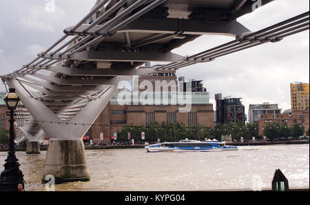 Blick über die Themse suchen, aus dem Norden Bank, die unter dem Millennium Fuß-Brücke auf dem Weg zur Tate Modern mit einem Passagier cruiser Stockfoto