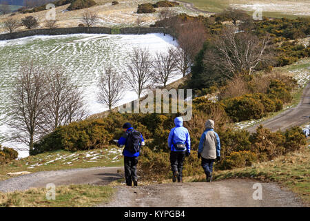 Drei Menschen tragen wasserfeste Kleidung mit Hauben bis zu Fuß in den Bergen von North Yorkshire zwischen Leyburn und Middleham nach einem Schnee Dusche Stockfoto