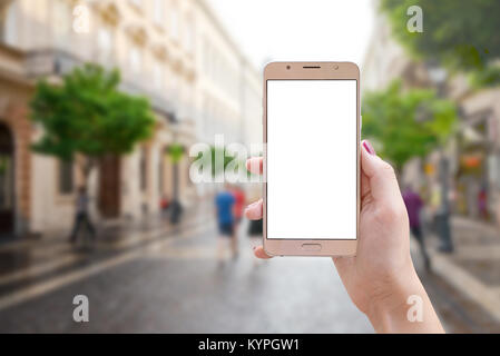 Smart Phone in der Frau die Hand auf Straße der Stadt. Isolierte leerer Bildschirm für Mockup, App oder Präsentation der Website. Stockfoto
