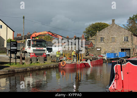 Tiefbau Fremdfirmen für den Kanal und Fluss vertrauen, D G Mühlen laden Baustoffe in einen Kanal arbeiten an Marple Wharf. Stockfoto