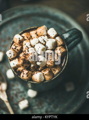 Winter wärmende süsses Getränk heiße Schokolade mit Marshmallows und Kakao in der Tasse über Graue Keramik Untertasse Hintergrund, selektiver Fokus Stockfoto