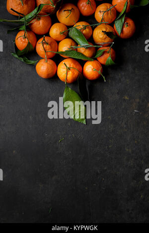 Clementine Orangen auf schwarzem Hintergrund Stockfoto