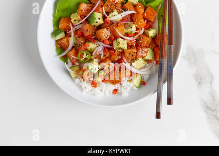 Lachs Poke von oben fotografiert in einer weißen Schüssel auf weißem Marmor Oberfläche. Stockfoto