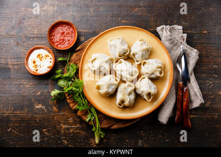 Traditionelle gedämpfte Teigtaschen Manty mit Joghurt und Tomatensauce. Stockfoto