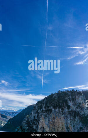 Chemtrails bilden eine perfekte Kreuz in den Himmel. Berge in Zagorochoria (Monodendri) in Epirus Griechenland Stockfoto