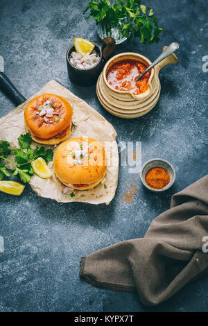 Würzige Pav Bhaji Masala gefüllt zwischen der Gebutterte Schieberegler Brötchen, gekrönt mit gehackten Zwiebeln und Koriander. Stockfoto