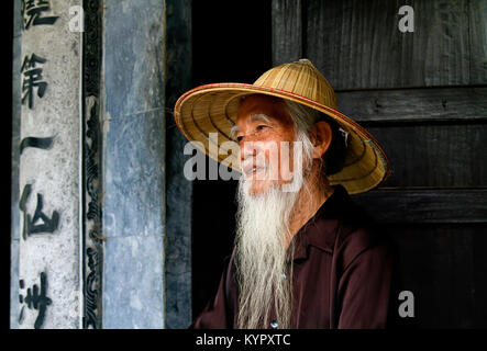 Alter Mann im Thai Vi Tempel, am Eingang nach Ninh Binh Höhle tal Trang Ein in der UNESCO eingetragen. Ninh Binh Provinz, Vietnam Stockfoto