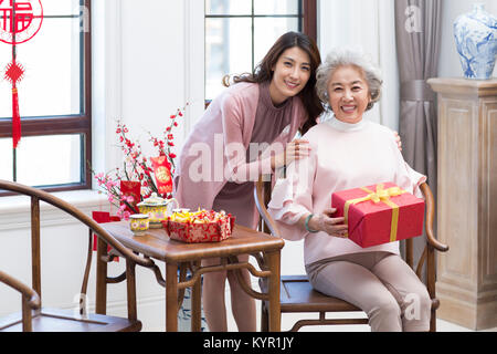 Tochter geben Geschenk zu ihrer Mutter während des chinesischen neuen Jahres Stockfoto