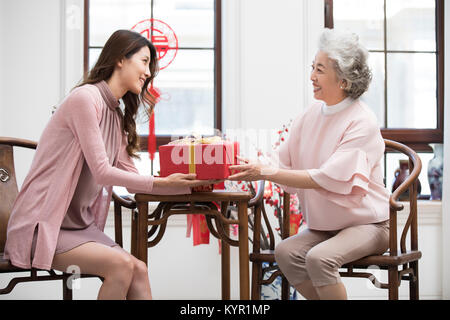 Tochter geben Geschenk zu ihrer Mutter während des chinesischen neuen Jahres Stockfoto