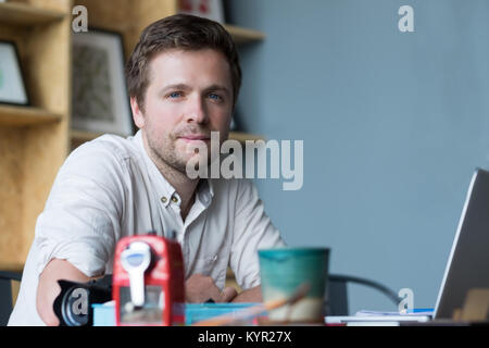 Close up Portrait von fröhlichen im mittleren Alter kaukasischer Mann an seinem Schreibtisch im Büro zu sitzen. Stockfoto