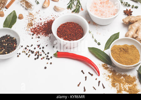 Auswahl von Gewürzen, Kräutern und Grünen. Zutaten zum Kochen. Weißer Hintergrund, kopieren. Stockfoto