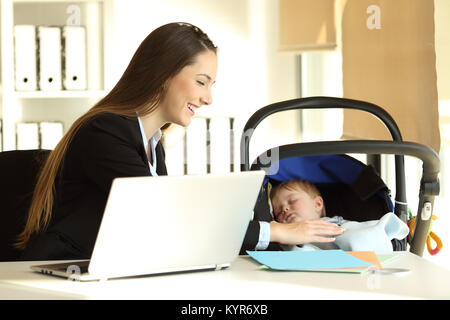 Glückliche Mutter arbeiten und kümmert sich um Ihr Baby Sohn im Büro Stockfoto