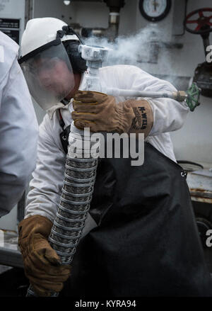 Us Air Force Airman 1st Class Jerry Timmons, 673 d Logistik Bereitschaft Squadron Brennstoffe Einrichtungen Techniker, bereitet ein 50-Liter flüssigem Sauerstoff Warenkorb Joint Base Elmendorf-Richardson, Alaska, Dez. 4, 2017 zu füllen. Sauerstoff wird unter Druck in flüssigem Zustand gekühlt, um es effizienter vom Tieftemperaturtanks zu JBER Aircraft und frische Luft zu Piloten im Flug zu transportieren. (U.S. Air Force Stockfoto