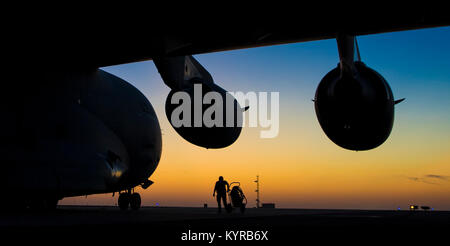 Ein US Air Force Crew Chief der Expeditionary 816th Airlift Squadron zugeordnet, kontrolliert eine C-17 Globemaster III nach einer Ladung Bewegung Mission am geheimen Ort, Vorderasien, Dez. 21, 2017. Die primäre Aufgabe der C-17 ist die schnelle strategische Bereitstellung von Truppen und verschiedene Arten von Ladung in Grundlagen der gesamten US Central Command sind der Verantwortung. (U.S. Air Force Stockfoto